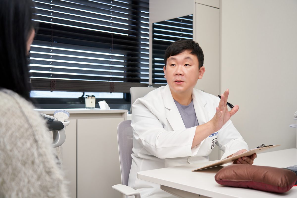 진료실에서 환자에게 통증의 원인을 설명하는 최철우 대표원장